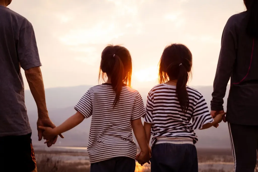 Familia caminando de la mano hacia la puesta de sol