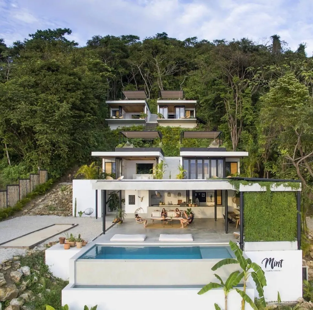 Hotel Mint — front view of the stepped hillside pavilions with the pool, green wall and hotel sign in Santa Teresa.