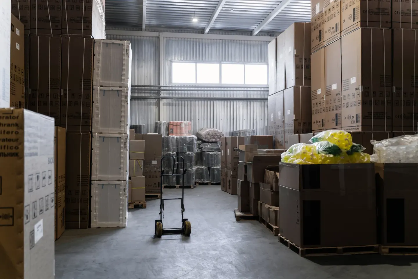 Interior de bodega con cajas y carretilla: organizado, predecible, todo donde debe estar